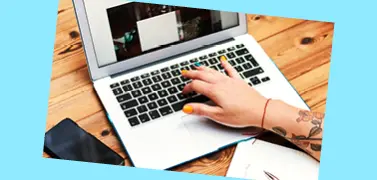 A grey color laptop on a table on a light blue background.