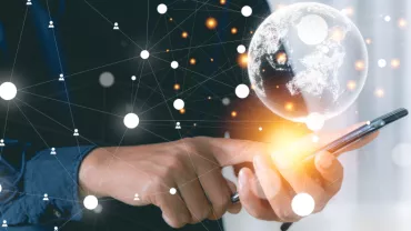 Man houdt smartphone vast met digitale wereldbol en netwerkverbindingen.