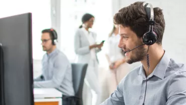 Klantenservicemedewerker draagt een headset op kantoor.