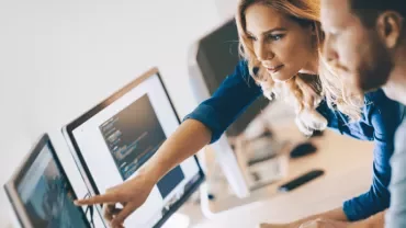 Twee mensen werken samen aan de computer