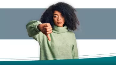 Persoon met groene trui geeft duim omlaag.