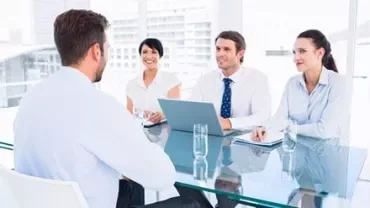 Zakelijke bijeenkomst in een kantoor met vier mensen rond een tafel
