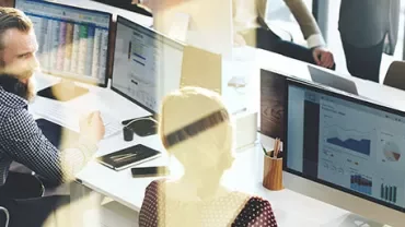 Kantooromgeving met mensen die op computers werken.