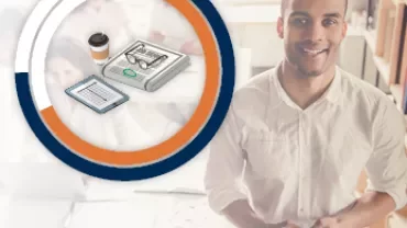 Person holding a phone with charts and electronics in background.