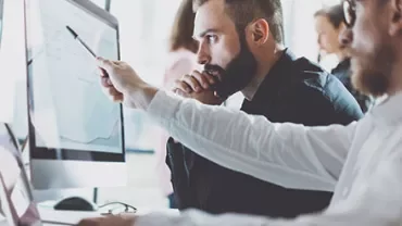 Two people collaborating at a computer screen.