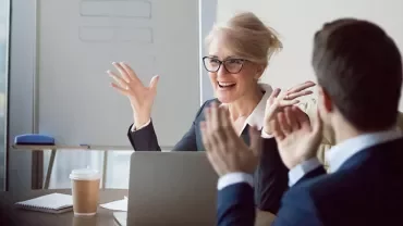 Zakelijke bijeenkomst in een kantoor met enthousiaste deelnemers.