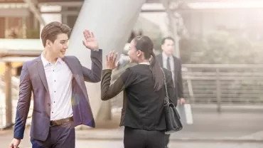 Two people high-fiving in a business setting.