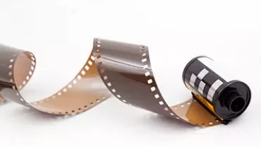 Een rol onontwikkelde film ligt op een witte achtergrond.