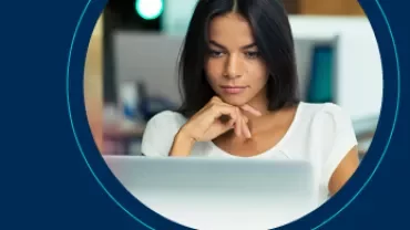 Iemand werkt geconcentreerd op een laptop in een kantooromgeving.