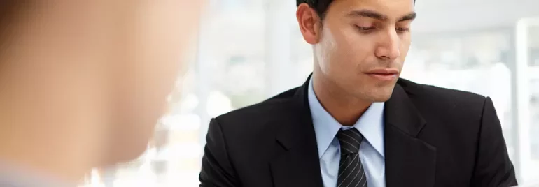 A person in a business suit reviewing papers.