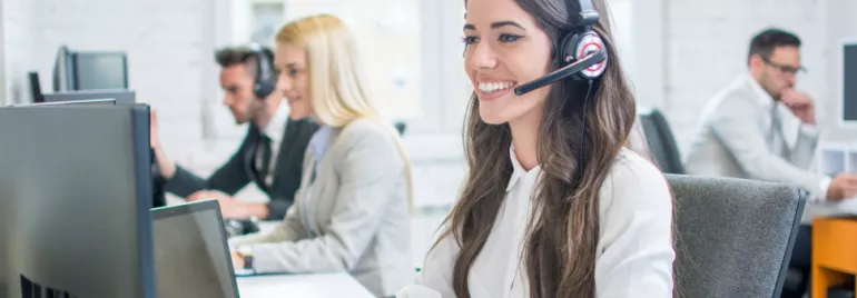 Klantenservicemedewerkers werken aan bureaus met headsets.