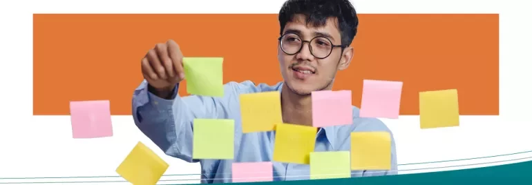 Persoon plaatst gekleurde sticky notes op glas.