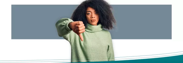 Person in green sweater giving thumbs down.