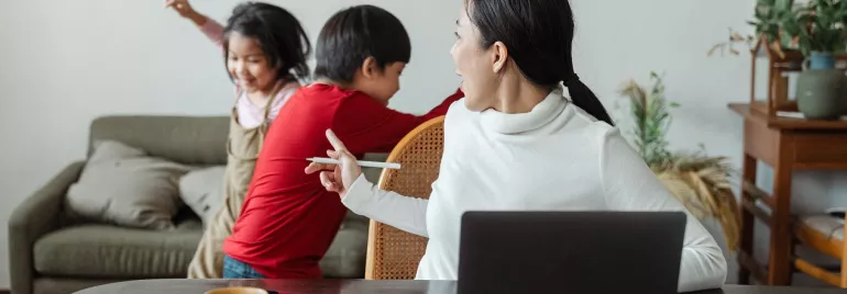 Vrouw kijkt naar kinderen die in de woonkamer spelen.