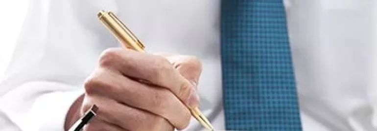 Hand met pen schrijft in een agenda