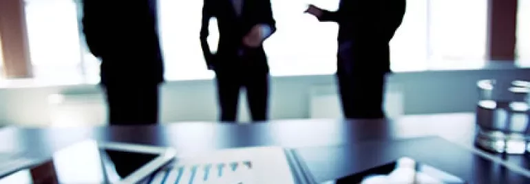 Group discussing in an office with charts on a table.