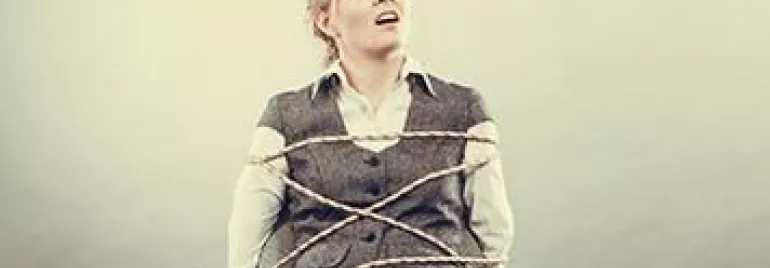 Person tied to a chair with rope, looking upwards.