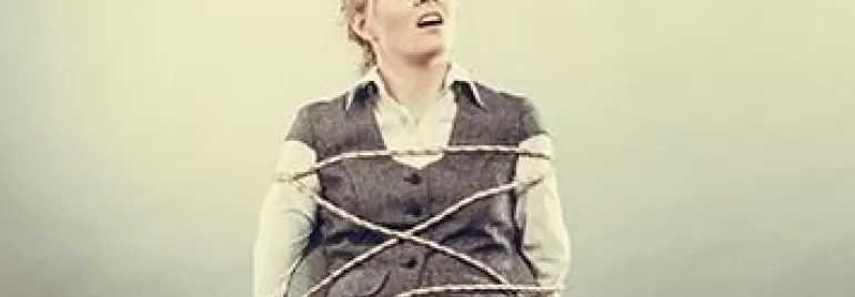 Person tied to a chair with rope, looking upwards.