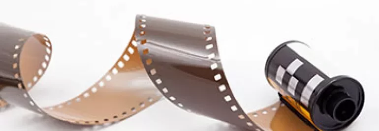 Een rol onontwikkelde film ligt op een witte achtergrond.
