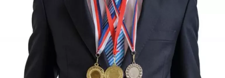 Man in pak met drie medailles om zijn nek.