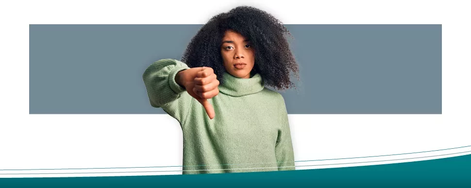 Persoon met groene trui geeft duim omlaag.