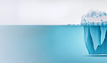 Een grote ijsberg drijvend in helder blauw water.