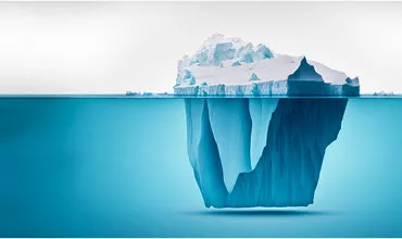 An iceberg floating with its larger part submerged underwater.