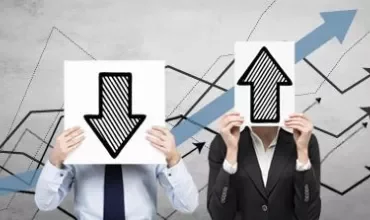 Two people holding arrow signs next to financial graphs.