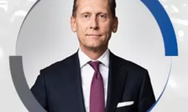 Person in a suit and tie in a circular frame.
