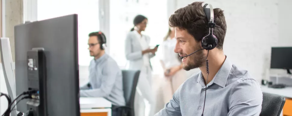 Klantenservicemedewerker draagt een headset op kantoor.