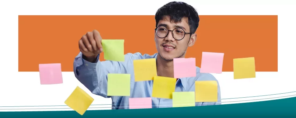 Persoon plaatst gekleurde sticky notes op glas.