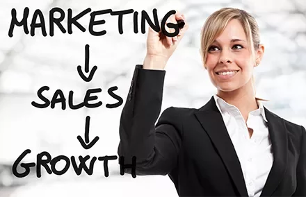 Persoon schrijft marketing, sales, groei op glas.