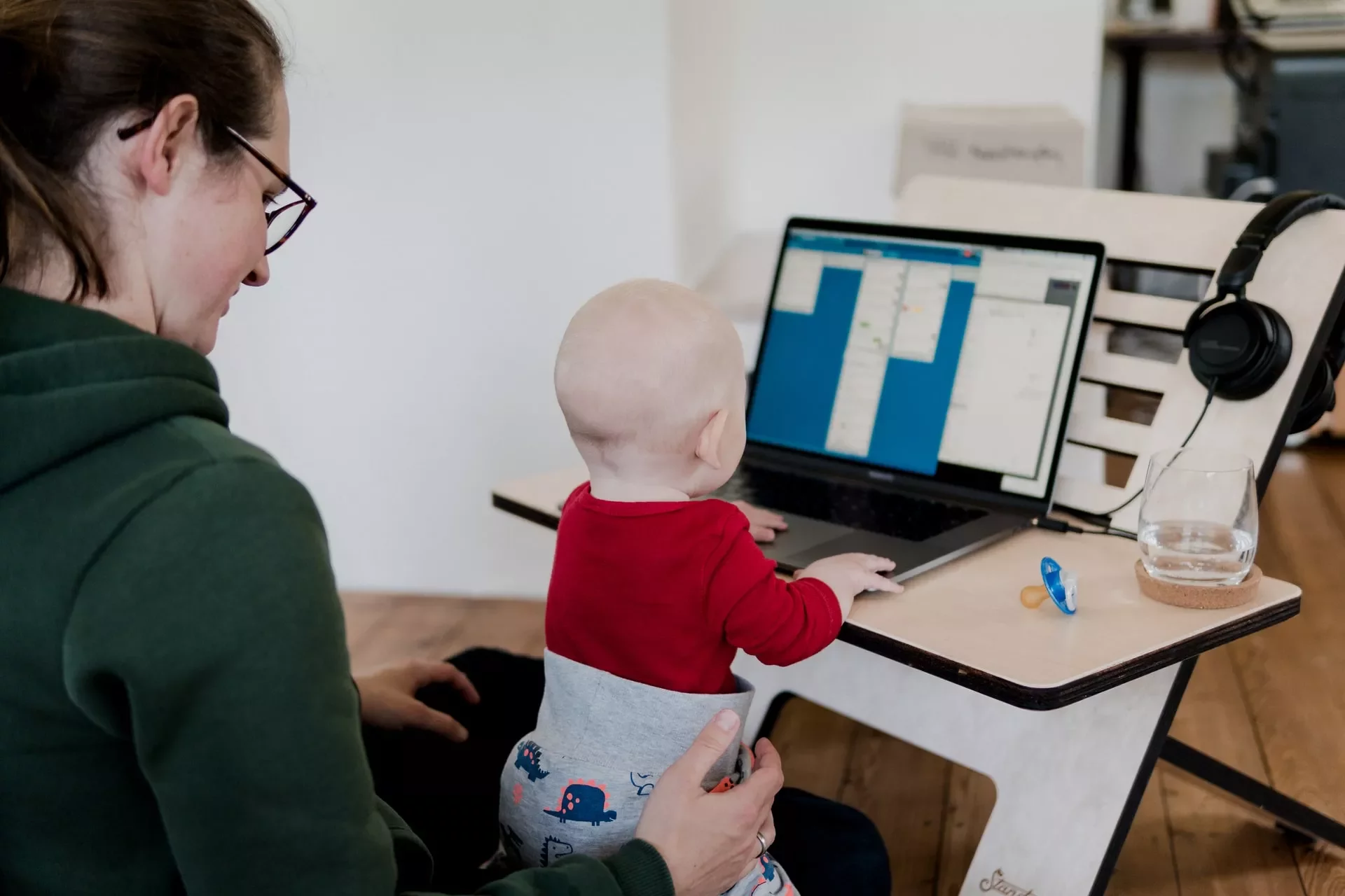 Adult with child on lap, looking at a laptop.