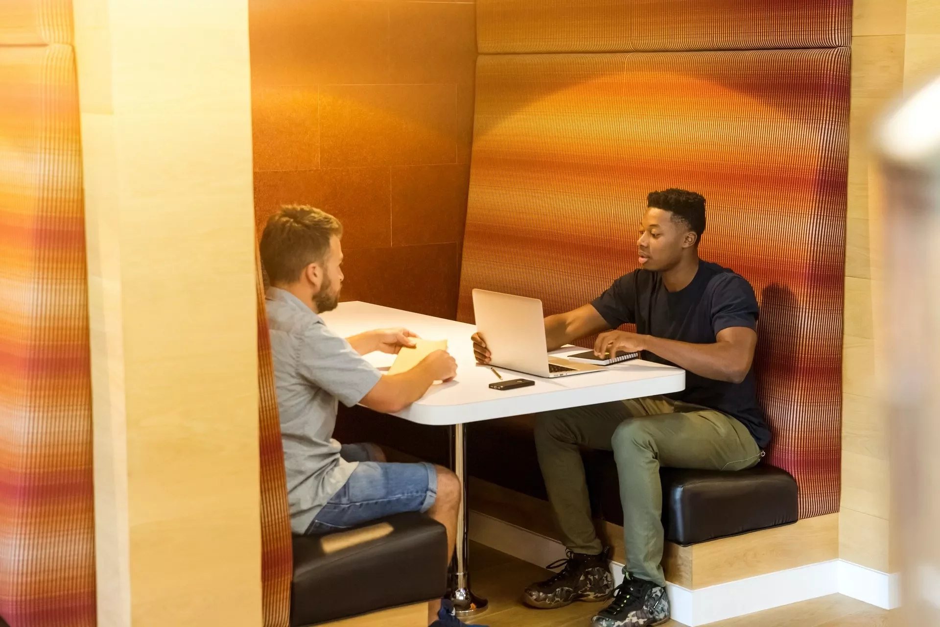 Two people having a conversation in a cozy workspace.